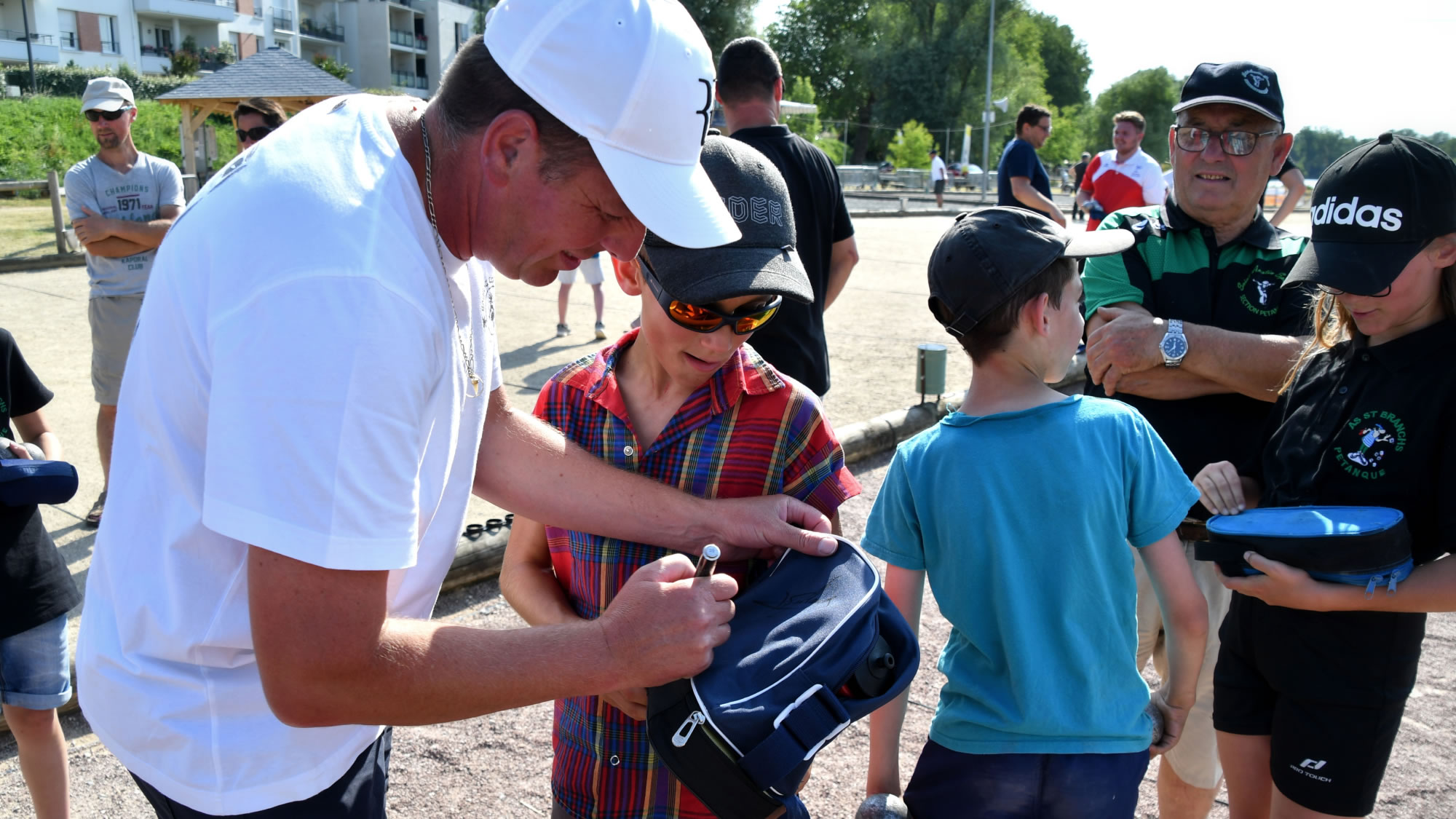 Philippe Suchaud signing autographs for the young pétanque players